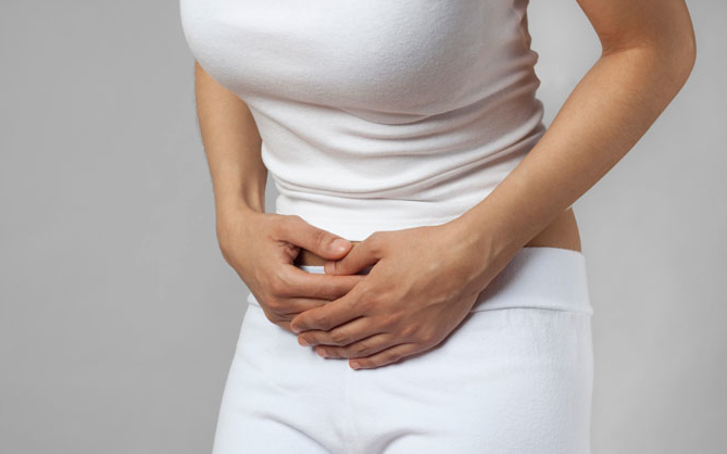 Mulher com dor no abdomen com possíveis sintomas da endometriose