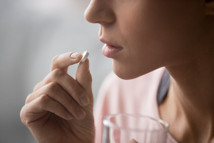 imagem de mulher tomando pílulas anticoncepcionais