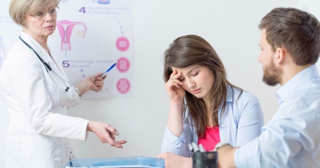 Casal em consulta com uma médica.