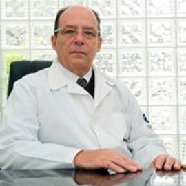 Dr. Luiz Paulo Bedoschi usando jaleco e sentado em uma cadeira branca