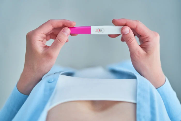 Visão superior de uma mulher segurando um teste de gravidez