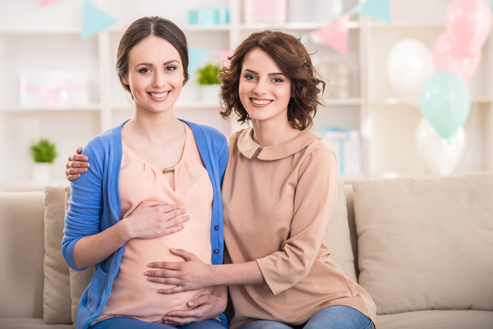 Mulher com mão na barriga de mulher grávida