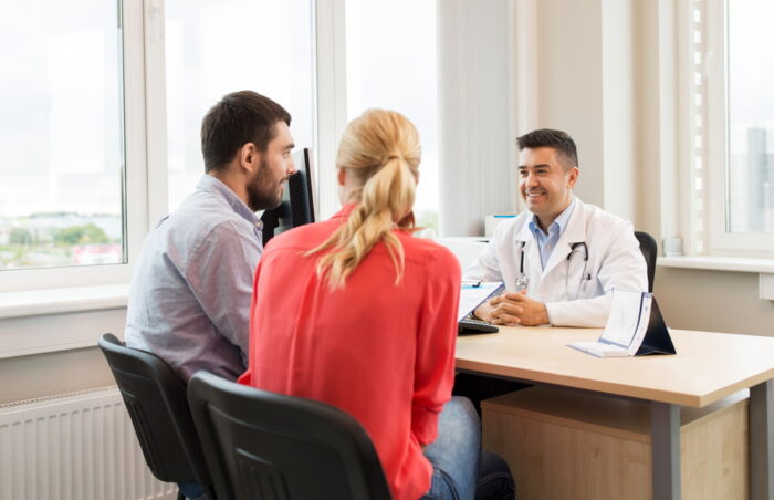 Casal em consulta com médico especialista em fertilização in vitro.