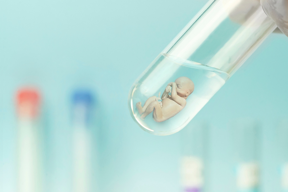 Um embrião humano em um tubo de vidro em um fundo azul de laboratório.