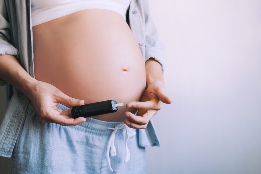 Mulher grávida segurando teste de diabetes