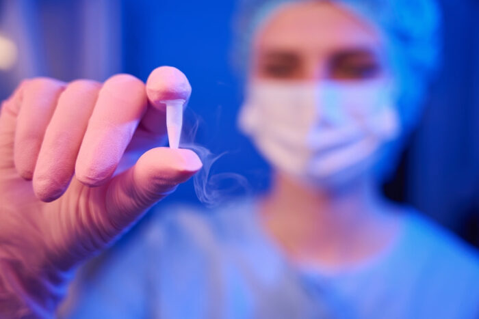 Médica segurando um recipiente para criopreservação.