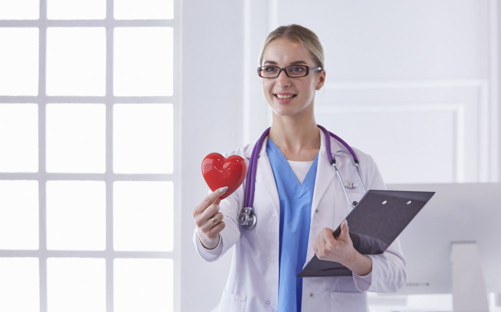 Médica especialista em congelamento de óvulos segurando coração na mão