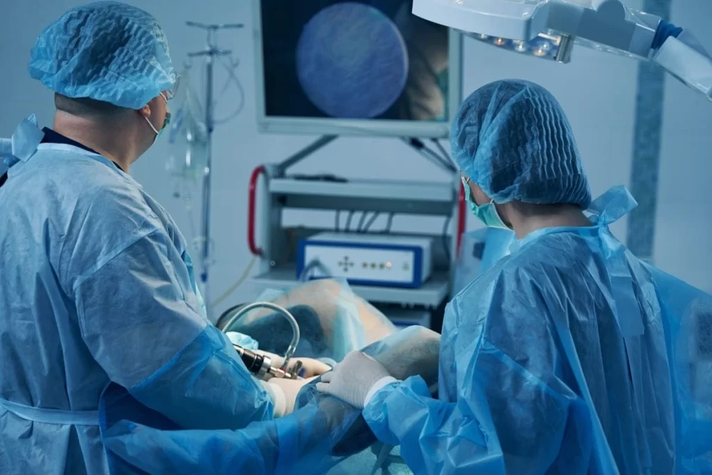 Médico em sala de exames ilustrando realização de histeroscopia.