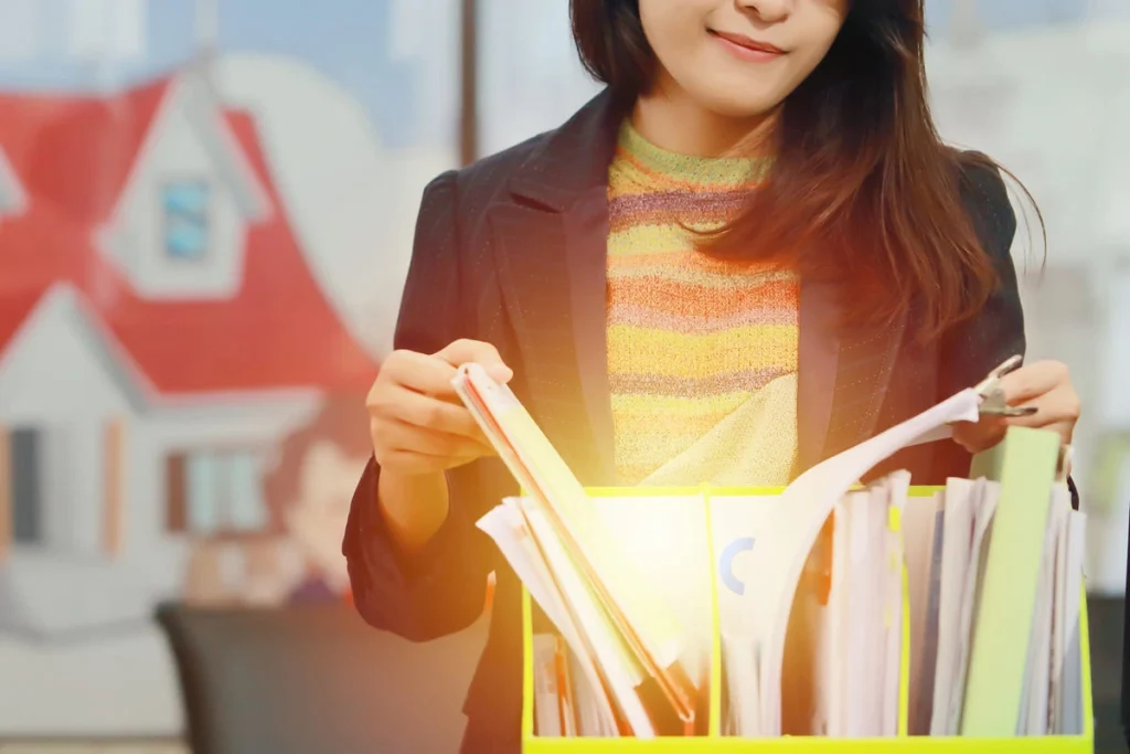 Mulher organizando documentos e pastas representando gastos com FIV para declaração de imposto de renda.