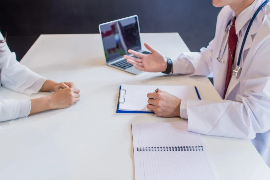 Médico conversando com paciente ilustrando os riscos da fertilização in vitro.
